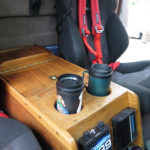 A custom walnut center console holds maps, flashlights, auxiliary locks and all small travel accessories. It incorporates cup holders specifically sized for our Aladdin travel cups.