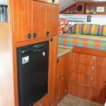 Next to the entry door is the refrigerator and cabinets purposely positioned over the wheel well.
